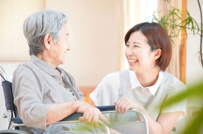 高齢の女性と歯科スタッフが笑顔で話をしているイメージ